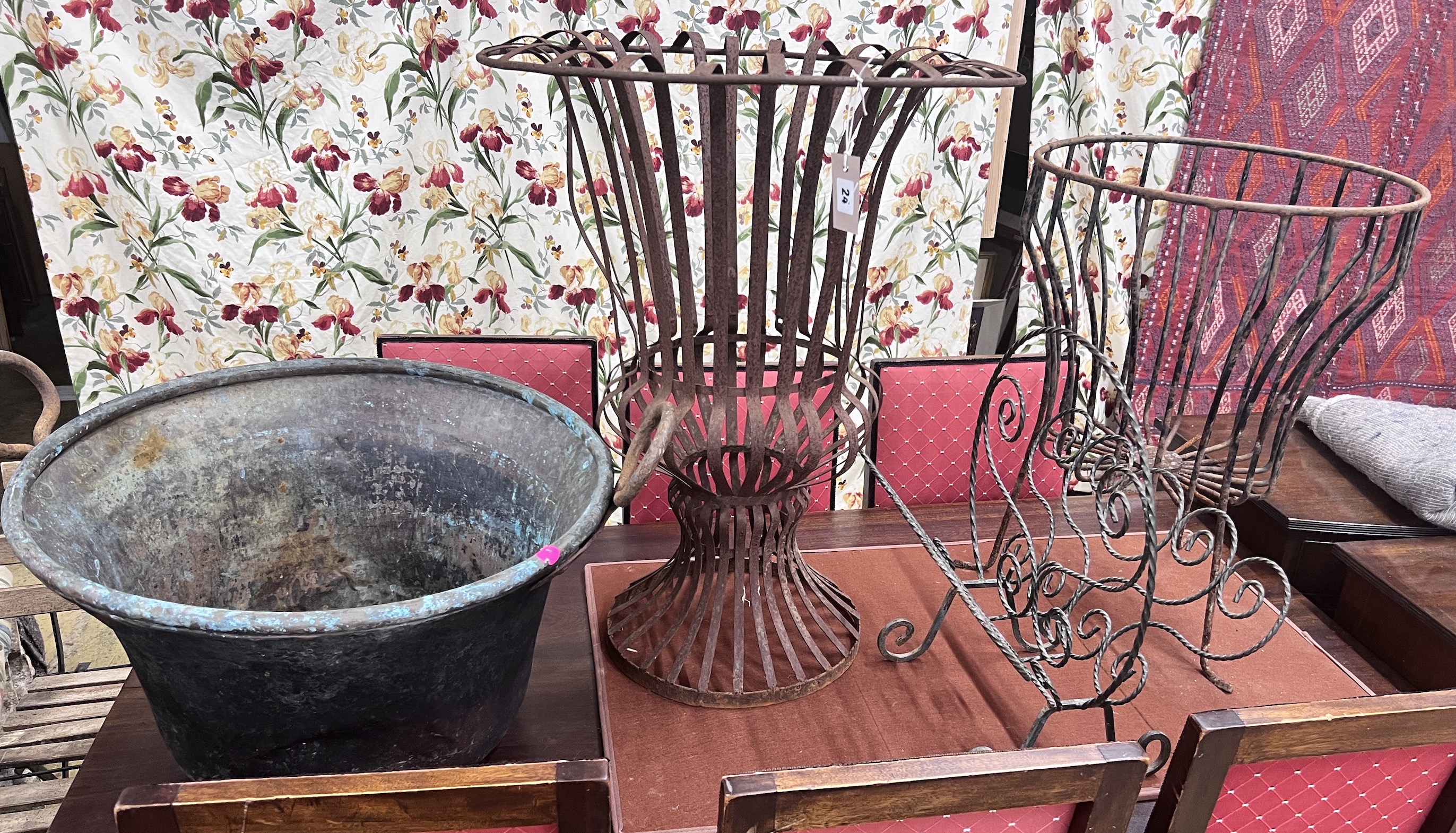 A pair of wrought iron circular garden frames, a magazine rack and a copper cauldron, largest height 78cm